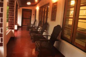 a row of chairs sitting in a hallway with a door at Patrius Bungalow by Daddy's Nest in Diyatalawa