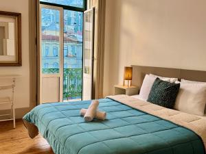 a bedroom with a bed with a teddy bear on it at Ambiente Hostel in Lisbon
