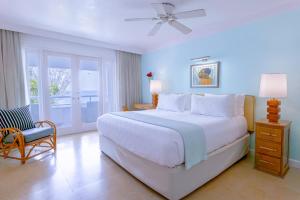 a bedroom with a large white bed and a chair at Couples Tower Isle in Ocho Rios +31 photos