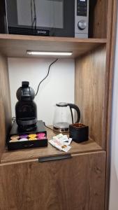 a cabinet with a coffee maker and a microwave at Boudoir-Art Studio Apartment in Debrecen