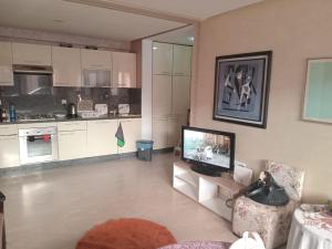 a living room with a television and a kitchen at Appartement pieds dans l'eau Aghroud in Tamri