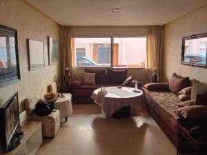 a living room with a couch and a table at Appartement pieds dans l'eau Aghroud in Tamri
