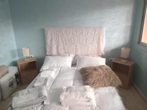 a bed with white sheets and pillows in a bedroom at Appartement pieds dans l'eau Aghroud in Tamri