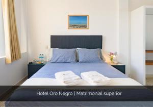 a bedroom with a bed with two towels on it at Hotel Oro Negro in Talara