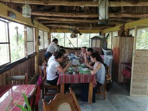 a group of people sitting at a table in a restaurant at Ecolodge Rancho del Lago in Santomé