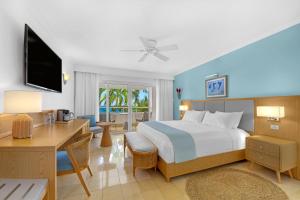 a bedroom with a bed and a desk with a computer at Couples Tower Isle in Ocho Rios