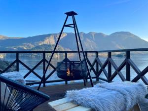 a room with a fire in a swing on a deck at FjordCabin Preikestolen in Strand