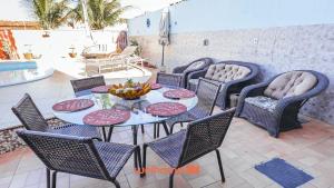 a table and chairs with a bowl of fruit on it at Suite em Guriri Norte com Piscina e Conforto in São Mateus