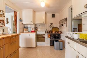 a large kitchen with white appliances and white cabinets at HAL820-Unnaryd-Soedra-vaegen-29-a in Unnaryd +15 photos