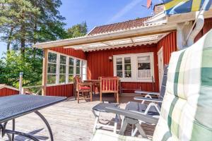 a red house with a deck with a table and chairs at HAL820-Unnaryd-Soedra-vaegen-29-a in Unnaryd