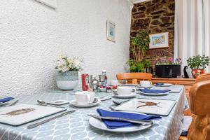 a table with plates and utensils on it at Capritia Guest House in Dartmouth +19 photos