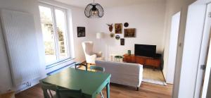 a living room with a table and a television at La Maison Trente in Chooz