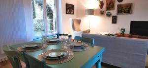 a dining room with a table with plates on it at La Maison Trente in Chooz