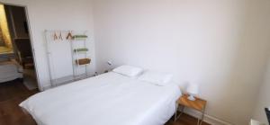 a bedroom with a white bed and a table at La Maison Trente in Chooz