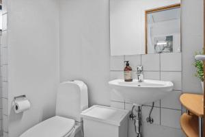 a white bathroom with a toilet and a sink at 3000-Stege-Stejlepladsen-13 in Stege +15 photos
