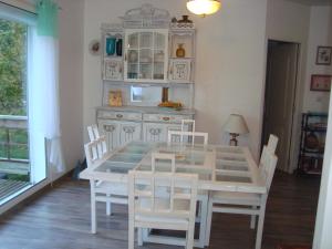 a dining room with a white table and chairs at Maison dans un écrin de verdure in Sorèze +4 photos