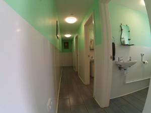 a hallway of a bathroom with a sink and a toilet at Clover in Welland