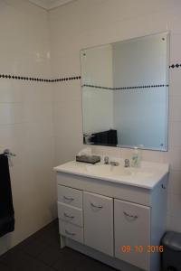 a bathroom with a white sink and a mirror at Morella Farmstay in Cape Jervis +19 photos