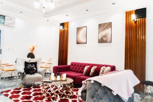 a living room with a red couch and a table at Hotel Saphir Group in Douala