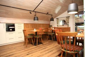 a dining room with wooden floors and tables and chairs at Gästehaus Margarita in Raubling