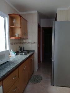 a kitchen with a refrigerator and a sink at ATICO ACOGEDOR LA LAGUNa in Las Lagunas
