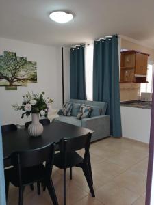 a living room with a table and a couch at ATICO ACOGEDOR LA LAGUNa in Las Lagunas
