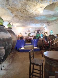 a room with several large vases and tables and chairs at Casa Rural Eufemia in Arenales de San Gregorio