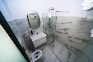 a bathroom with a toilet and a mirror at Sunrise Rooms in Bucharest