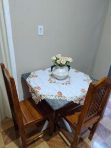 a table with a vase of flowers on it at Casa Hospedagem 01 in Foz do Iguaçu