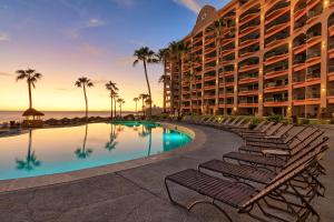 a resort pool with lounge chairs and the ocean at Wait 'n Sea Retreat Spacious Oceanfront Condo in Puerto Peñasco