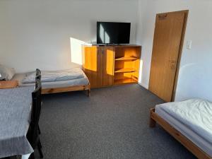 a small room with two beds and a tv at Freundliche Monteurwohnung in Bad Oldesloe