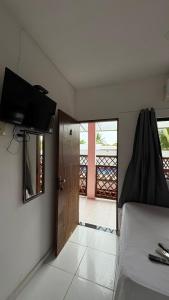 a bedroom with a bed and a door with a balcony at Pousada Manancial in Itaúnas