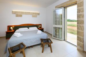a bedroom with a bed and a large window at Agriturismo Tenuta Calitre in Melendugno +117 photos