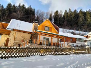 a house in the snow with a fence at Ferienhaus Bauer Wohnung 2 in Trattenbach