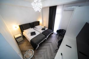 a bedroom with a bed and a chandelier at Sunrise Rooms in Bucharest