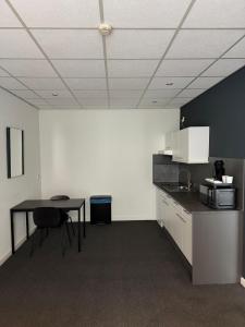 a room with a kitchen with a table and a microwave at Hotel & Appartementen Royal in Sas van Gent +21 photos