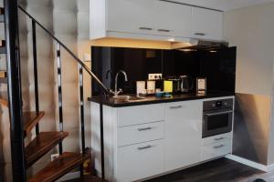 a kitchen with white cabinets and a sink at City Attic Haarlem in Haarlem