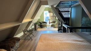 a room with a staircase with a bed and chairs at City Attic Haarlem in Haarlem