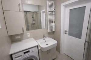 a bathroom with a sink and a washing machine at Apartment Katamaran in Krakow