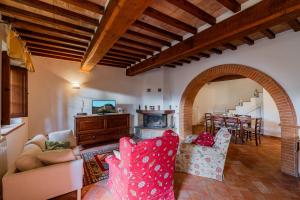 a living room with two chairs and a fireplace at Casa Vecciano in Cetona