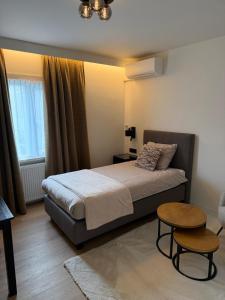 a bedroom with a bed and a table and a chair at Hotel & Appartementen Royal in Sas van Gent