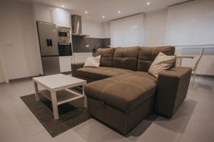 a living room with a brown couch and a table at Casas del Pedregal Apartamento 1 in A Estrada
