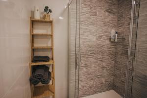 a shower with a glass door in a bathroom at Casas del Pedregal Apartamento 1 in A Estrada