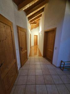 an empty hallway with wooden doors and a tiled floor at Gästehaus Cavallo in Achberg