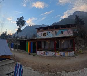 a building with a rainbow flag on the side of it at Kasol Shalom Camps & Cafe in Kasol