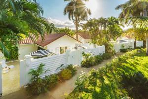 a house with a white fence and palm trees at Couples Tower Isle in Ocho Rios
