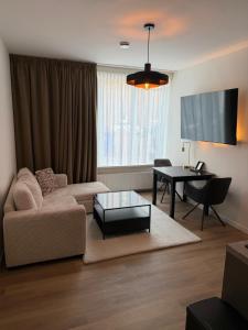 a living room with a couch and a table at Hotel & Appartementen Royal in Sas van Gent