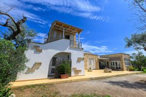 a large white house with a porch and a balcony at Agriturismo Tenuta Calitre in Melendugno