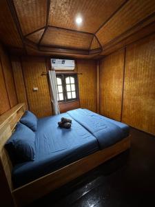 a bedroom with a blue bed with a phone on it at Ploy Chumpoo Kantiang in Ko Lanta +7 photos