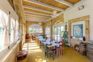 a dining room with a long table and chairs at Agriturismo Tenuta Calitre in Melendugno